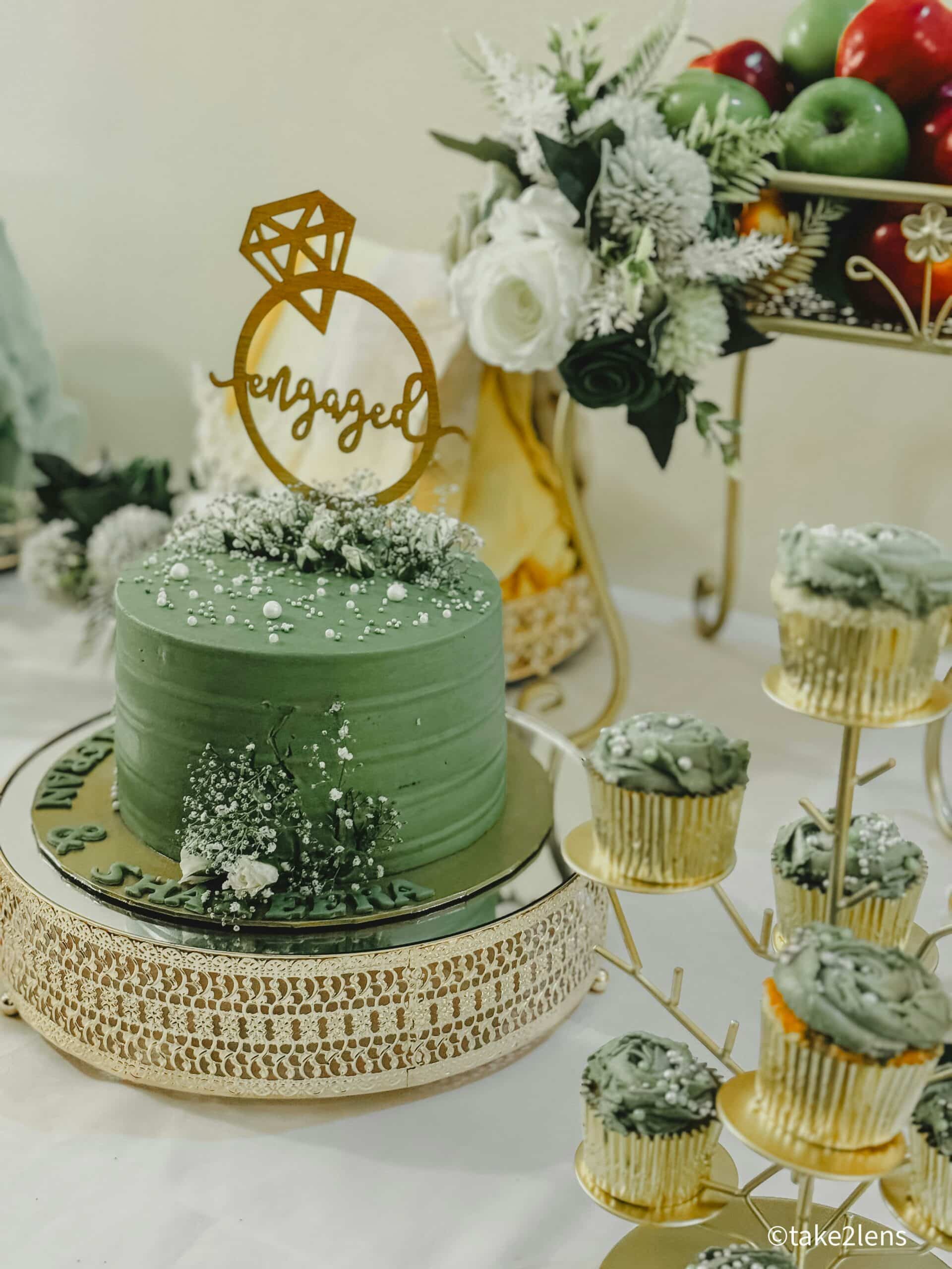 Green engagement cake with ring topper and matching cupcakes