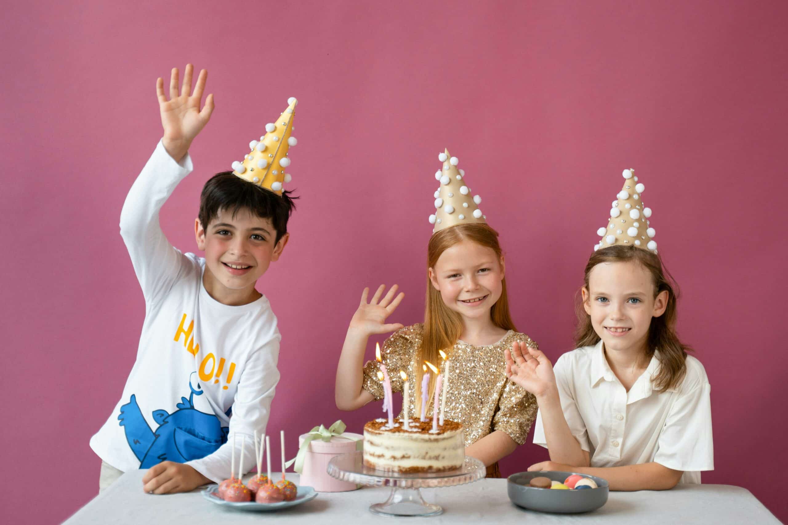 Children wearing party hats celebrating birthday with cake and candles