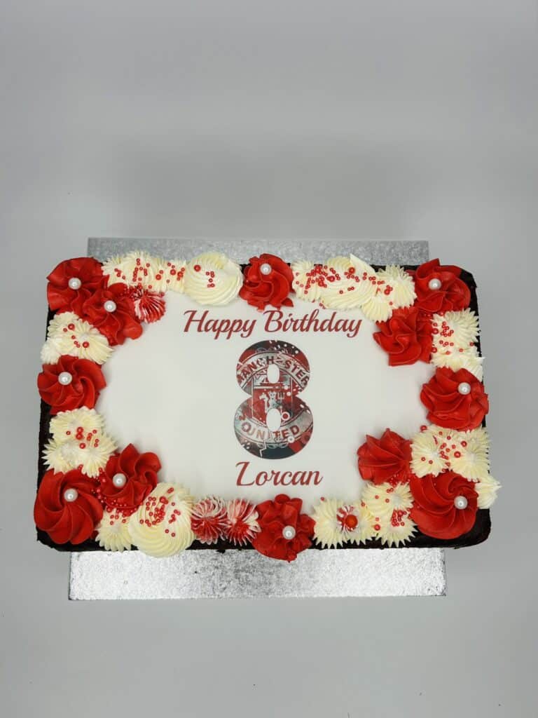 Rectangle birthday cake with red and white icing and Manchester United theme