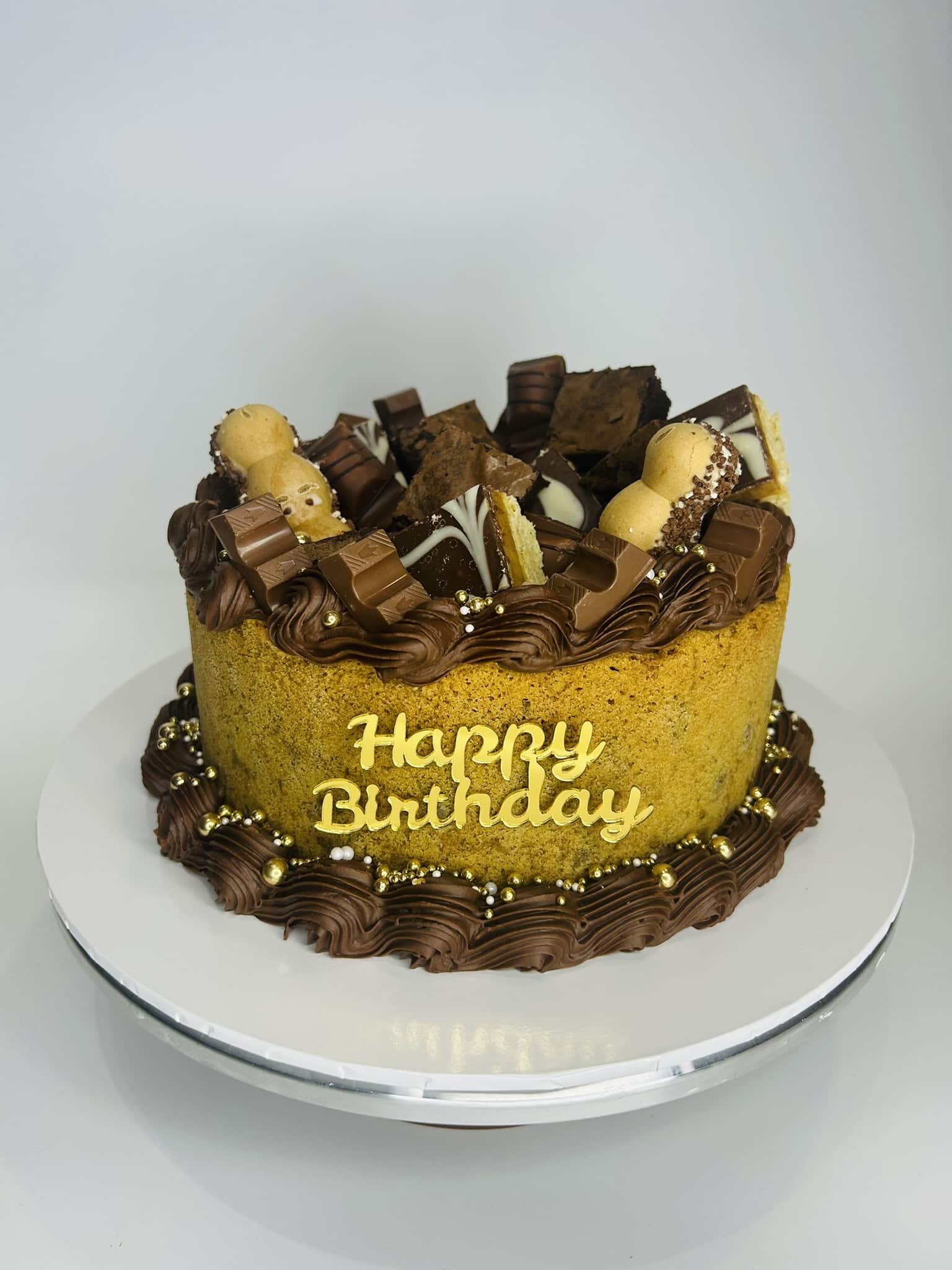 Chocolate birthday cake with sweets and “Happy Birthday” message