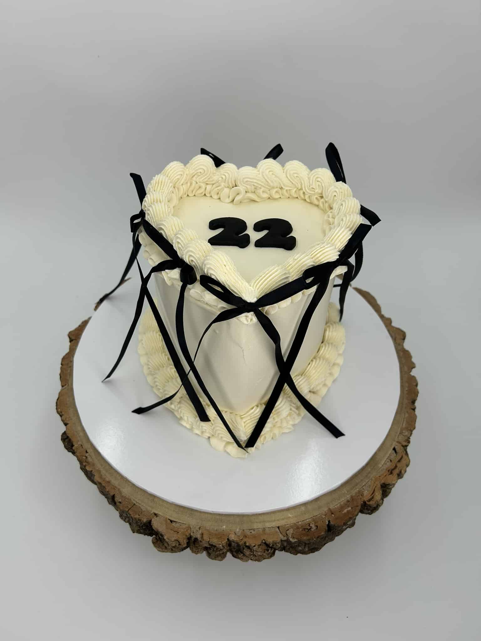 Heart-shaped cake with number 22 and black ribbon decoration