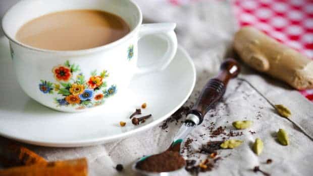 Cup of tea in floral teacup with spices on table