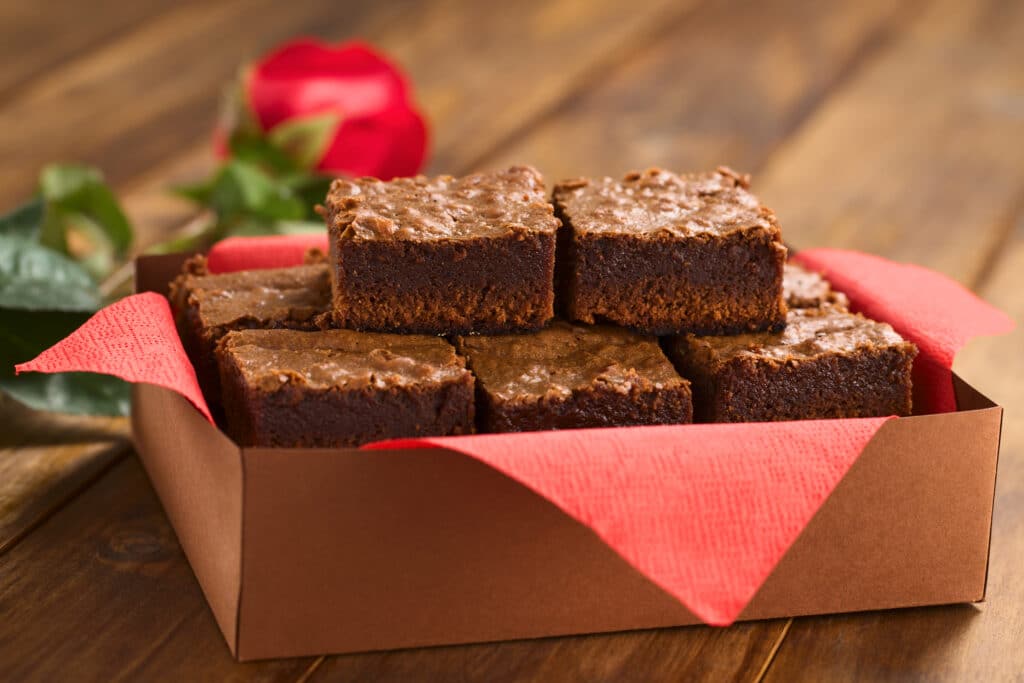 Chocolate brownie squares in a box with red napkin
