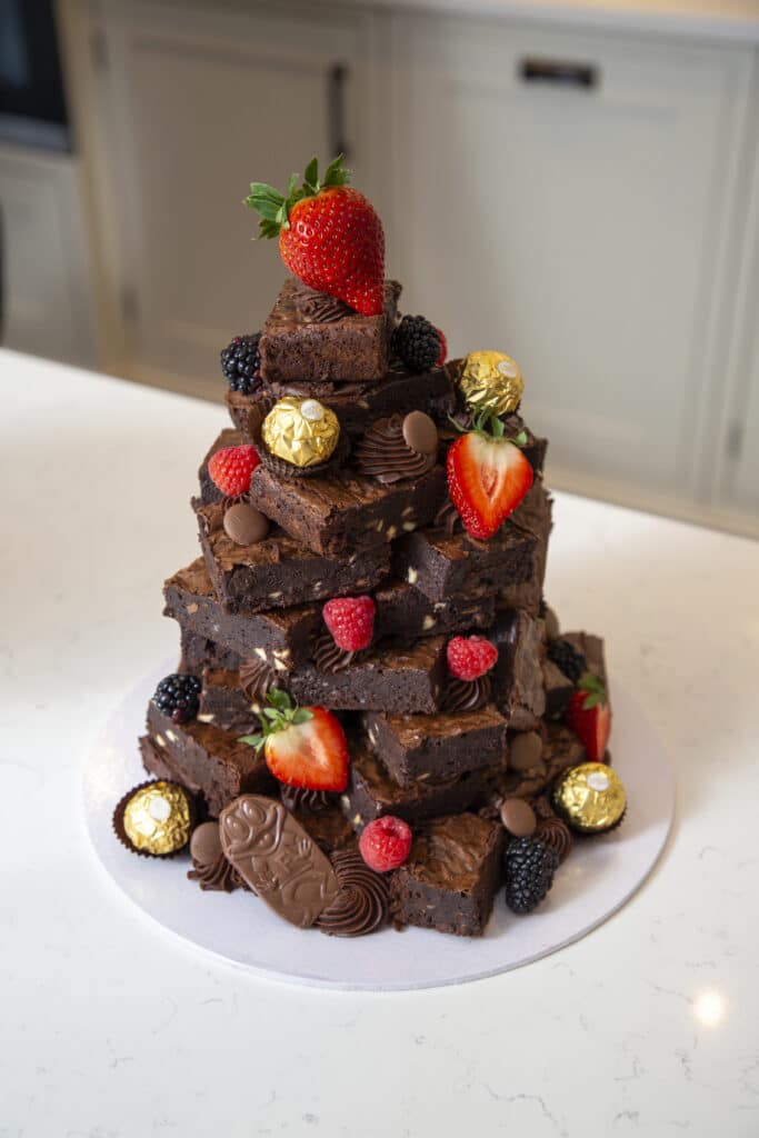 Stacked chocolate brownies with strawberries, berries and chocolates