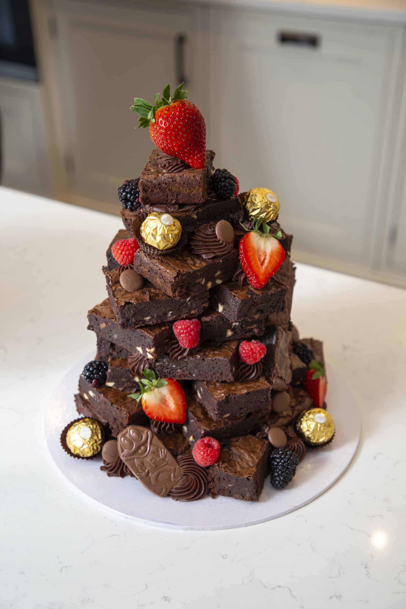 Stacked chocolate brownies with strawberries, berries and chocolates