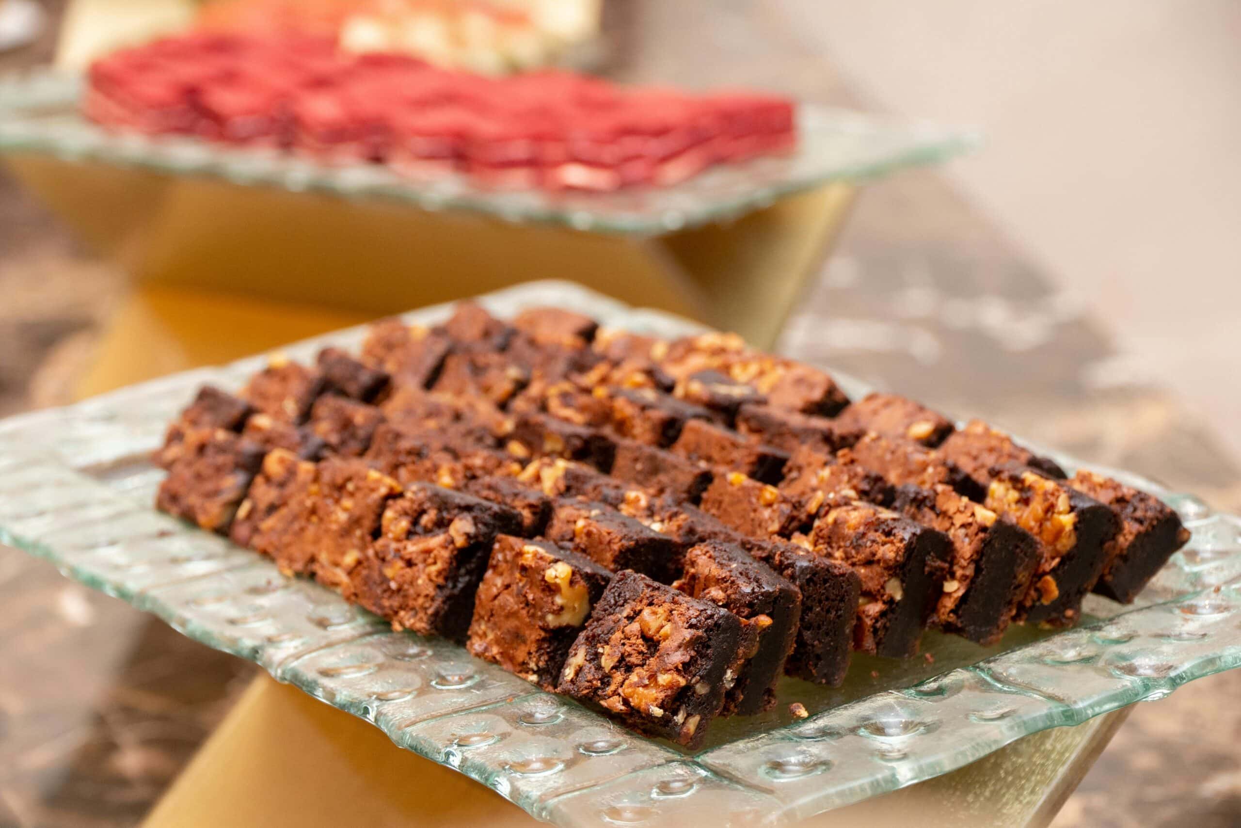 Mini chocolate brownie bites with nuts on a glass tray