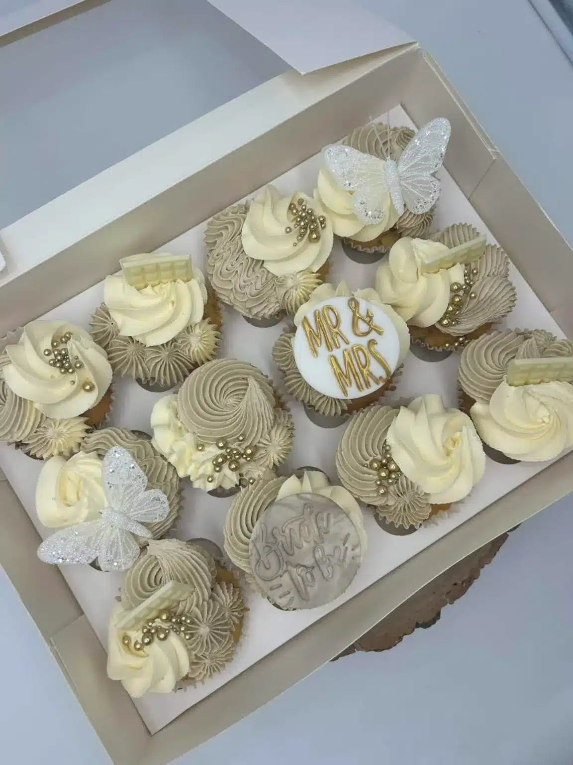 Box of wedding cupcakes with “Mr & Mrs” topper and butterfly decorations