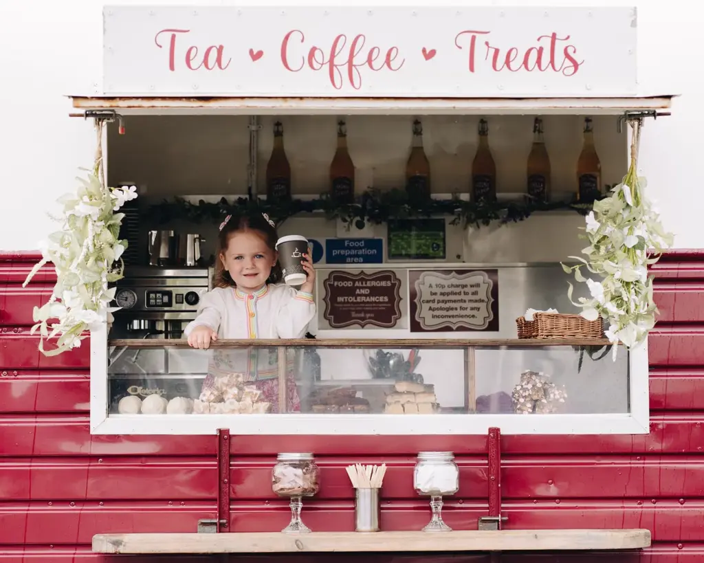 Tea and coffee treats stall with cakes and smiling vendor