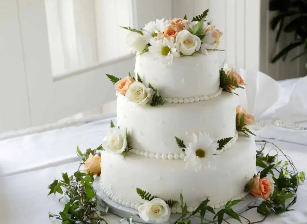 Three-tier white wedding cake with floral decorations